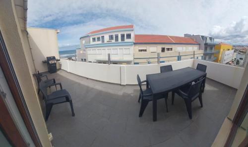 un balcone con tavolo e sedie su un edificio di Pé n'areia a Praia de Mira