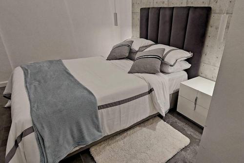 a bedroom with a large bed with white sheets and pillows at Modern design 1br in downtown Luanda in Luanda