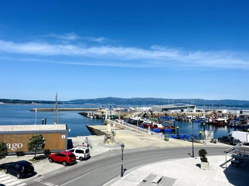 een jachthaven met auto's geparkeerd bij een jachthaven met boten bij Apartamento frente al mar in Villanueva de Arosa