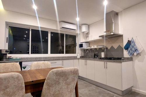 a kitchen with a wooden table and chairs and a dining room at Modern design 1br in downtown Luanda in Luanda