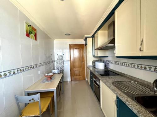 een kleine keuken met een aanrecht en een wastafel bij Apartamento frente al mar in Villanueva de Arosa