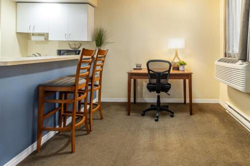 a kitchen with a desk and chairs in a room at Hôtel Saint-Laurent Montréal in Montréal