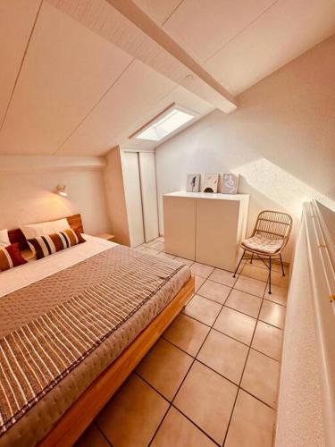 une chambre avec un lit et une chaise dans une pièce dans l'établissement Charmant T2 rénové avec vue mer, à Cervione