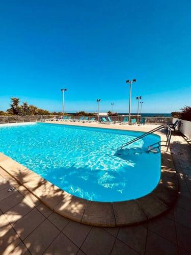 une grande piscine d'eau bleue et éclairée dans l'établissement Charmant T2 rénové avec vue mer, à Cervione