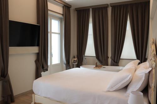 a bedroom with a large bed and a tub at Villa Nonna Cicci Boutique Hotel - SPA in Cisterna dʼAsti