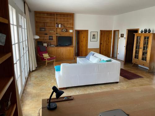 sala de estar con sofá blanco y TV en Villa Vista Pannonia, en Donnerskirchen