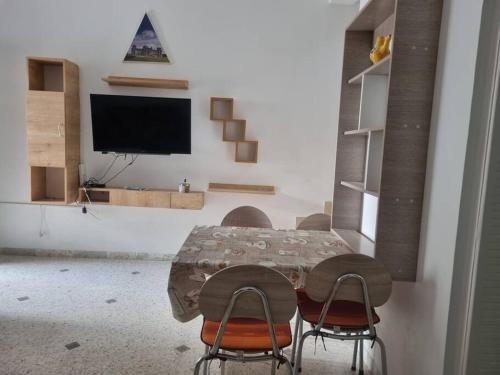 ein Esszimmer mit einem Tisch und Stühlen sowie einem TV in der Unterkunft Hammamet (Zone Les Orangers Hotel) in Hammamet Sud