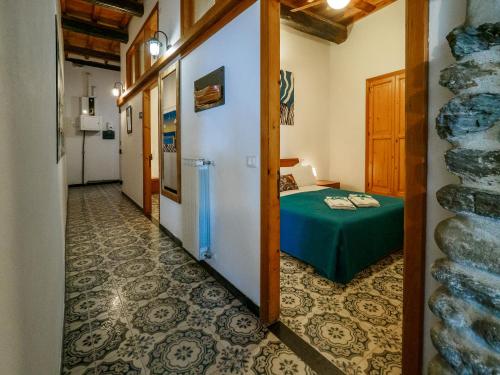 a corridor of a room with a green table and a bed at Unda de Ma Apartment with views and AC in Vernazza