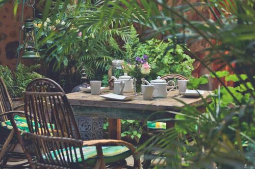 a table with chairs and cups and flowers on it at Mukima Manor in Nanyuki