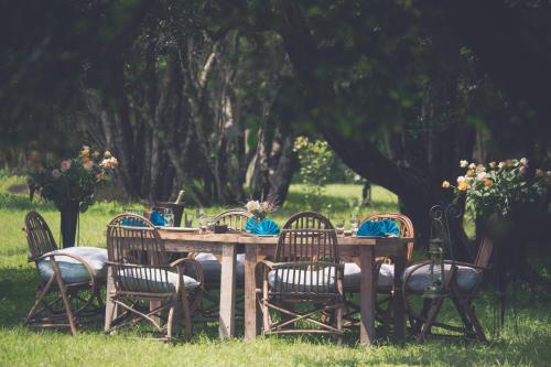 a wooden table with chairs around it in the grass at Mukima Manor in Nanyuki