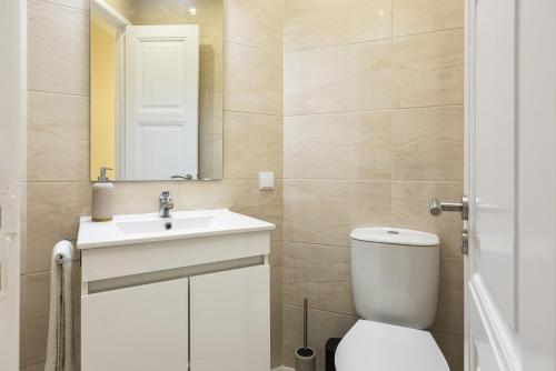 een badkamer met een toilet, een wastafel en een spiegel bij City Rooms - Amesterdao - Private room by HD in Faro