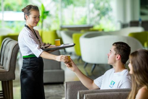 a woman giving a man a snack in an office at Muong Thanh Holiday Muine Hotel in Mui Ne