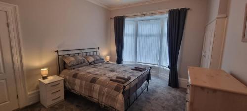 a bedroom with a bed and a large window at Traditional 3-Bed House on the Historic Headland in Hartlepool