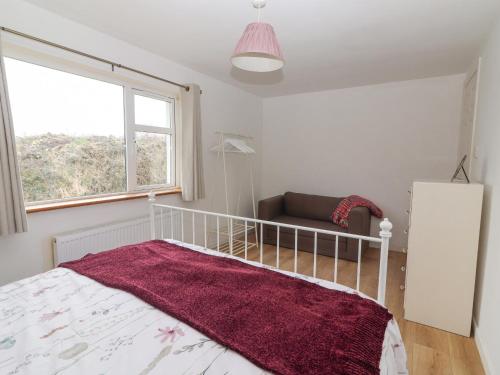 a bedroom with a bed and a couch and a window at White Cottage in Abbeyfeale