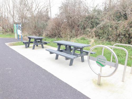 a couple of picnic tables in a park at White Cottage in Abbeyfeale