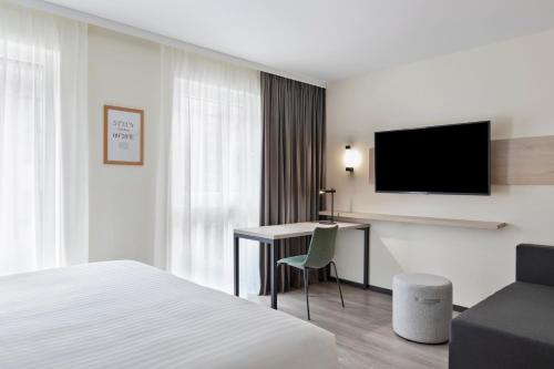 a hotel room with a bed and a desk and a television at Residence Inn by Marriott Hamburg Altona in Hamburg