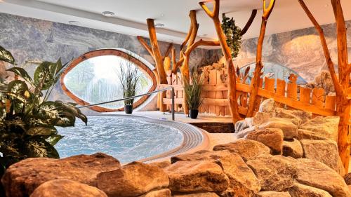 a jacuzzi tub in a room with rocks at Hotel Kocourkov in Hlinsko