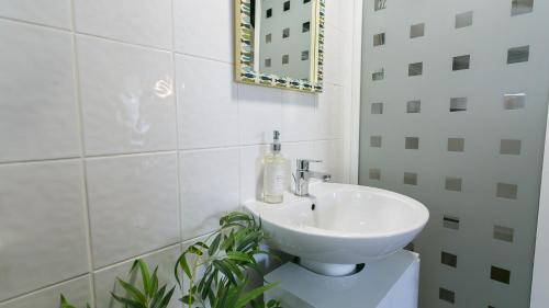 a bathroom with a white sink and a mirror at Hen Dafarn in Nefyn