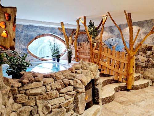 a room with a stone wall and a pool at Hotel Kocourkov in Hlinsko