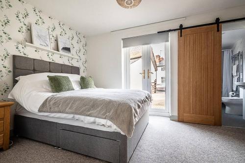 OttertonにあるPass the Keys Modern and accessible bungalow in village locationのベッドルーム(大型ベッド1台付)、バスルームが備わります。