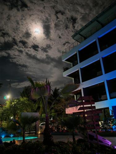 a view of a building at night with the moon at Surf One in Sosúa