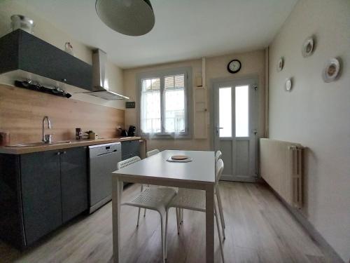 a kitchen with a white table and chairs in it at gite de la tour carrée in Montrichard
