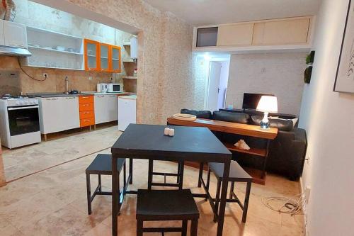 uma cozinha e sala de estar com uma mesa e um sofá em Moody & cozy 1br in city center em Luanda