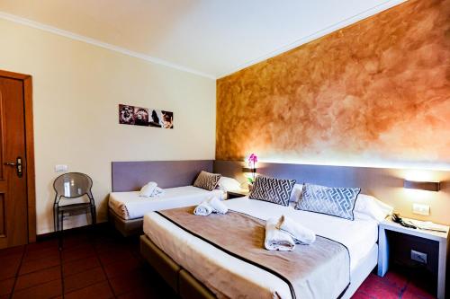 two beds in a hotel room with two dogs on them at Albergo Firenze in Florence