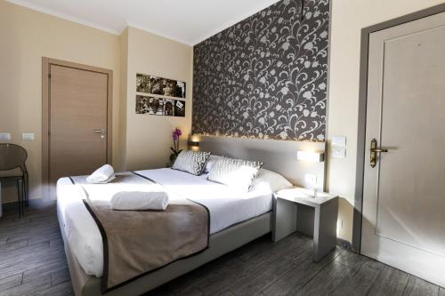 a bedroom with a bed with a black and white wall at Albergo Firenze in Florence