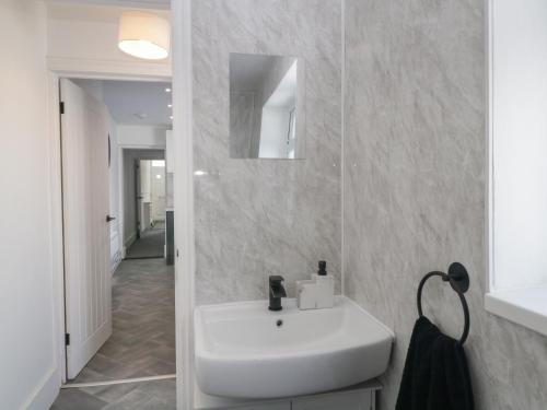 プリマスにあるGlenmoreのバスルーム(白い洗面台、鏡付)