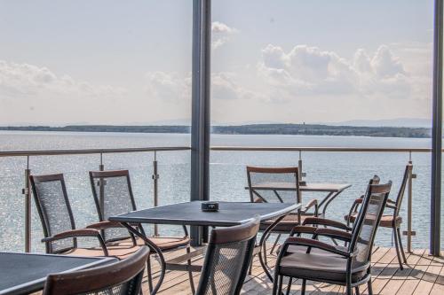 a balcony with tables and chairs and the water at Hotel Eurobus in Kaluža