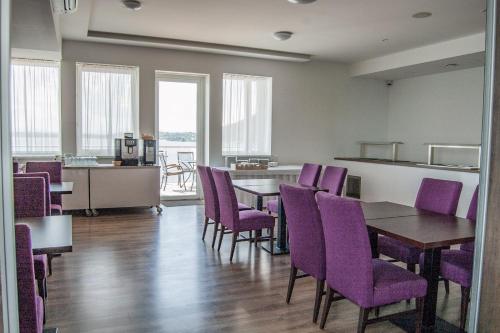 a dining room with purple chairs and a table at Hotel Eurobus in Kaluža
