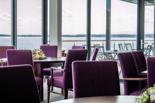 a room with tables and chairs with a view of the water at Hotel Eurobus in Kaluža