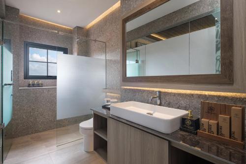 un baño con lavabo y espejo en The Margaux Hotel Yogyakarta, en Yogyakarta