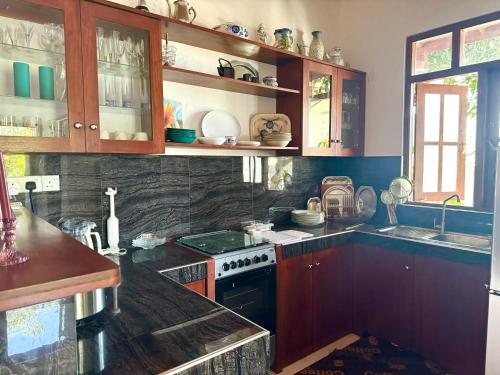 a kitchen with wooden cabinets and a stove top oven at Casa Dei Sogni in Hikkaduwa