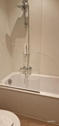 La salle de bains est pourvue d'une baignoire avec un robinet. dans l'établissement Hotel Des Zouaves, à Coxyde