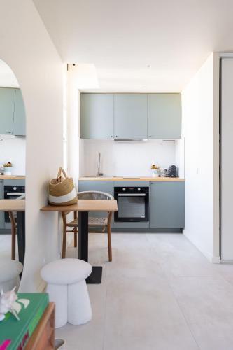 une cuisine avec des armoires blanches et une table et des chaises dans l'établissement Sweet Cocoon in a city center, à Marseille