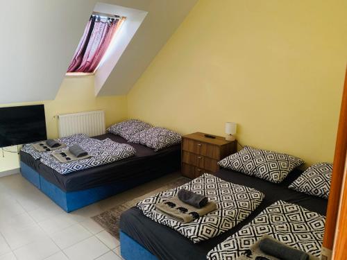 2 camas y un sofá en una habitación en Balaton Grill Szállás Siófok en Siófok