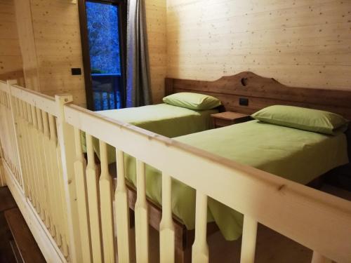 2 camas en una habitación con barandilla de escalera en Agriturismo Le Rocher Fleuri, en Bard
