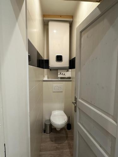 a small bathroom with a toilet and a door at Le Refuge T3 centre ville 63m2 pied des montagnes in Albertville