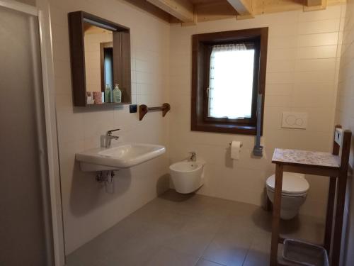 La salle de bains est pourvue d'un lavabo et de toilettes. dans l'établissement Agriturismo Le Rocher Fleuri, à Bard