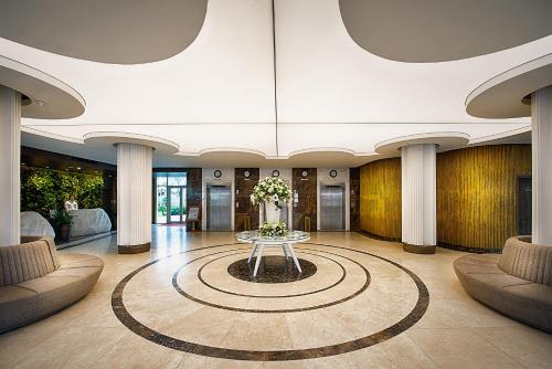 a lobby with a table with flowers on it at Muong Thanh Holiday Muine Hotel in Mui Ne