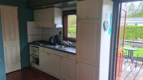 a small kitchen with a sink and a window at Bospark Lunsbergen - LB 76 in Borger