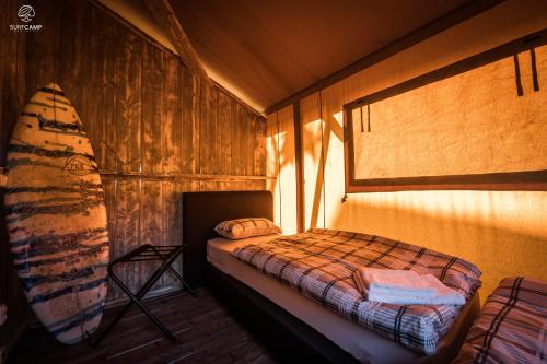 a bedroom with a bed and a surfboard in it at Oasis Camp Portugal in Lagoa