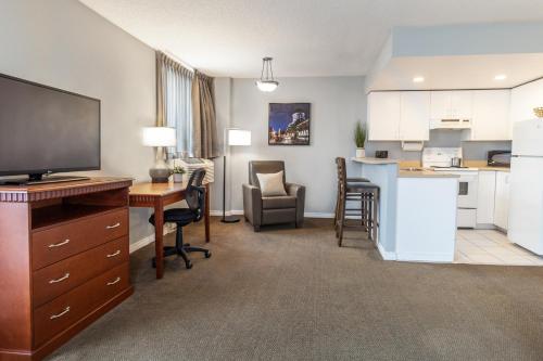 a room with a kitchen and a living room with a desk at Hôtel Saint-Laurent Montréal in Montréal