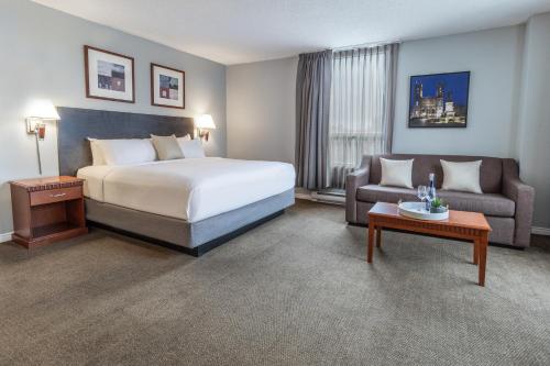 a hotel room with a bed and a couch at Hôtel Saint-Laurent Montréal in Montréal