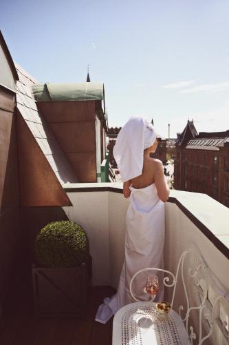 a woman in a white dress on a balcony at Hotel Bella Grande in Copenhagen