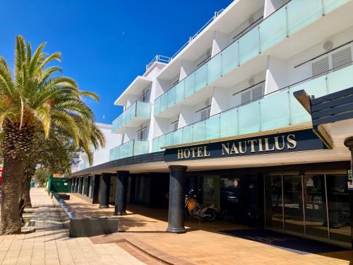 a hotel with a palm tree in front of it at Nautilus Hotel in Roses