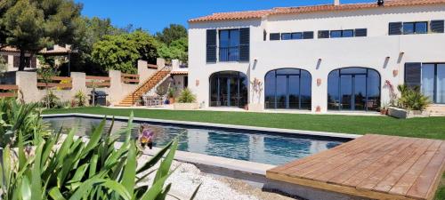 une maison avec une piscine devant une maison dans l'établissement Les Cactus Bleus, à Sausset-les-Pins