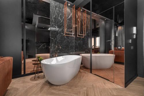 シュチェチンにあるMARGI Velvet Apartament 13TH FLOOR LED CEILING BATH POOLの大きな白い浴槽と洗面台のあるバスルーム